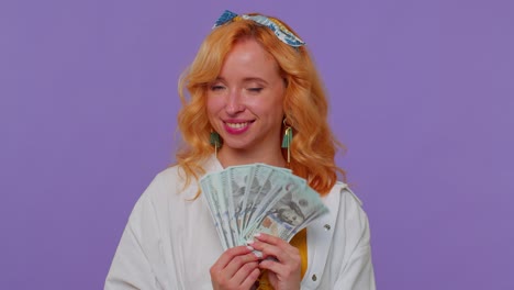 Proud-arrogant-rich-stylish-girl-holding-money-cash-in-dollars-banknotes,-smiling,-looking-at-camera