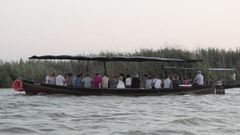 Barco-Lleno-De-Turistas-Paseando-Por-La-Albufera-Valenciana-Al-Atardecer