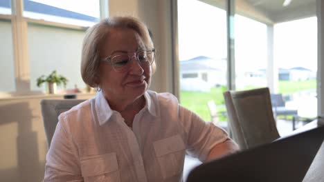 senior-woman-smiles-in-approval-while-reading-the-results-on-a-computer-screen