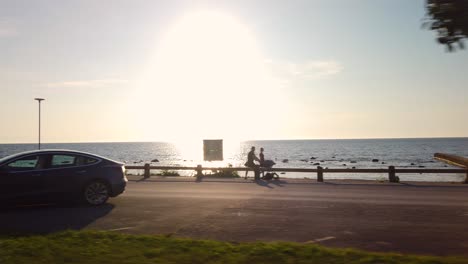 Sunset-by-Visby-on-Gotland-coast-in-summer,-tourists-on-vacation,-POV-from-road-trip-in-Sweden