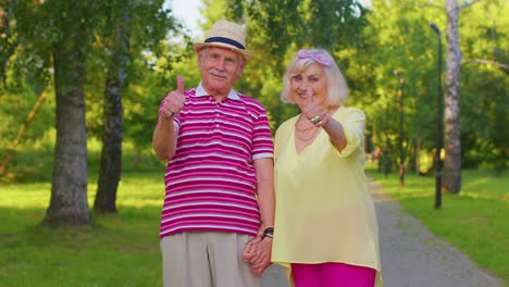 Senior-stylish-couple-grandmother-grandfather-looking-approvingly-showing-thumb-up-like-sign-gesture