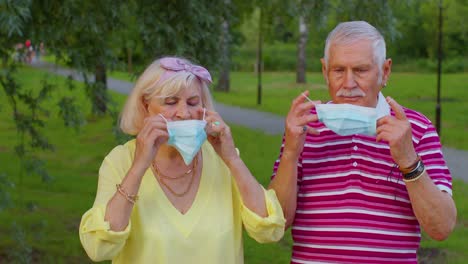 Senior-family-grandmother-and-grandfather-wearing-medical-protective-mask-in-park-during-coronavirus