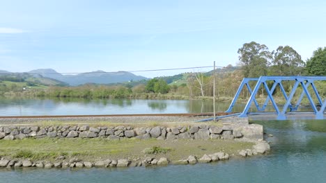 Aerial-dolly-sideways-along-Railway-bridge-over-the-Rada-River,-Colinders