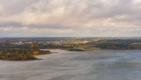 Time-lapse-of-windy-sea-and-clouds-moving-over-the-fall-colored-Viikki,-Helsinki