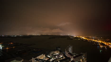 Time-lapse-of-storm-clouds-moving-over-the-night-lit-Kulosaari-island,-Helsinki