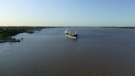 Aerial:-Oil-tanker-ship-sailing-in-Suriname-river,-clear-sky-background