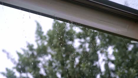 Rain-water-drops-falling-tent-gutter-spilling-through,-slow-mo