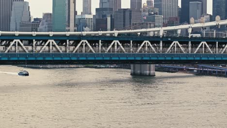 Drohnen-LKW-Schwenk-über-Die-Manhattan-Bridge,-Während-Die-U-Bahn-Von-New-York-Die-Brücke-über-Wasser-überquert