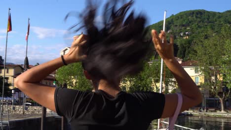 Mujer-Joven-Con-El-Pelo-Atado-Cerca-Del-Muelle-De-Laveno-Mombello,-Lago-Maggiore,-Lombardía,-Italia