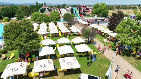 Luftaufnahme-Eines-Belebten-Aquaparks-Mit-Farbenfrohen-Wasserrutschen,-Pools-Und-Schattigen-Bereichen