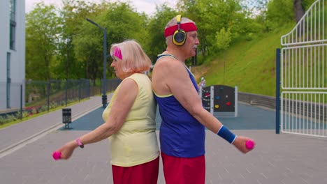 Active-elderly-old-sports-team-grandmother-grandfather-weightlifting-dumbbells,-smiling-at-camera