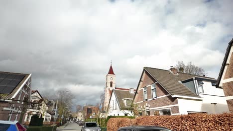 Navegando-Por-El-Pintoresco-Pueblo-Tradicional-Holandés-De-Oosterbeek,-Que-Muestra-Encantadoras-Casas-Y-Una-Notable-Iglesia-Reformada.