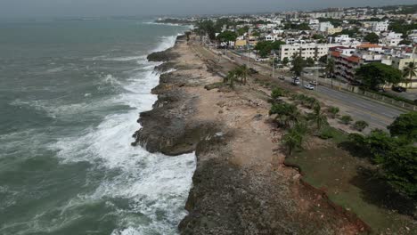 Aerial-backward-view-of-ocean-waves-crashing-against-the-rocky-coastline-of-Santo-Domingo-after-Hurrican-Beryl,-Dominican-Republic