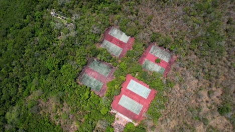 überwucherte-Tennisplätze-In-Verlassenen-Tropischen-Resort---Hurrikan-Schäden---Luftaufnahme-Aufsteigend