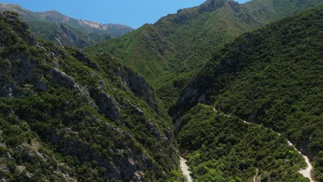 Drone-flying-through-mountains-in-Parga,-Greece-with-tight-opening