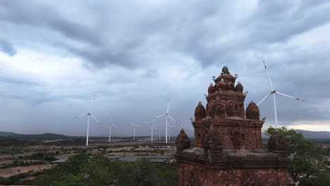 Ancient-Cham-temple-nestled-in-a-modern-wind-farm,-old-new