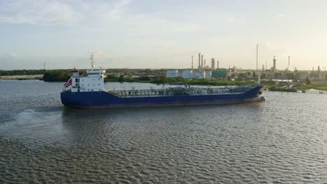 Aerial:-Oil-tanker-ship-getting-in-place-to-dock-to-Staatsolie-refinery,-Suriname-river