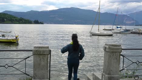 Mujer-Viajera-Caminando-Por-El-Muelle-De-Laveno-Mombello-En-Varese,-Italia