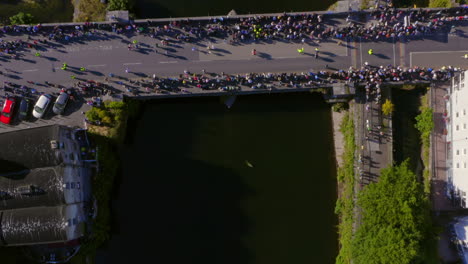 Crowd-gathered-at-O'Briens-bridge-for-the-arts-festival-parade,-unaware-of-a-large-seal-swimming-in-the-Corrib-River