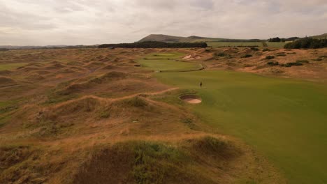 Hombre-En-El-Campo-De-Golf-De-Scottish-Links-Al-Atardecer