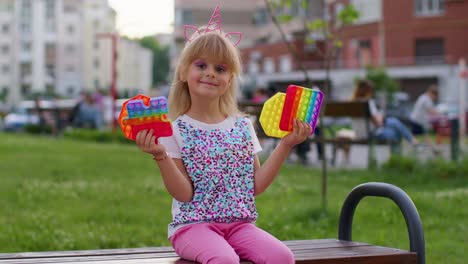 Niña-Linda-Y-Elegante-Que-Muestra-Burbujas-Blandas-Con-Pantalla-Táctil-De-Silicona,-Juguetes-Sensoriales-Pop-It