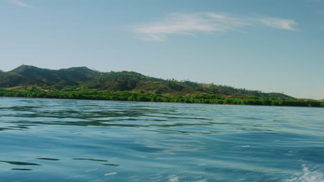 Tropical-paradise-with-placid-calm-water-reflecting-green-and-blue,-slow-motion