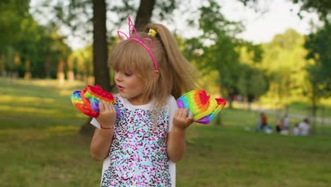 Female-child-girl-showing-push-pop-it-bubble-fidget-stress-anxiety-relief-squeeze-sensory-game-toys