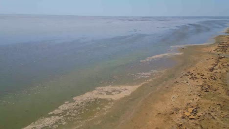 Aerial-FPV-shot-of-salt-water-lake,-clear-water-at-Road-connecting-Khavda-to-Dholavira-in-Kutch,-Road-to-Heaven-Gujarat,-India-4K-Drone