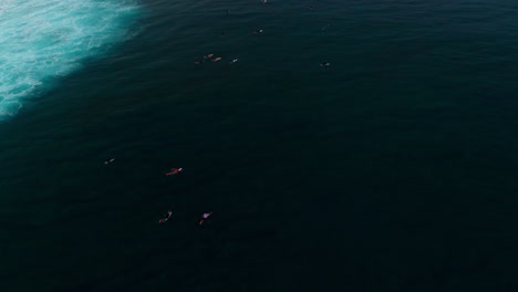 Eine-Drohne-Erhebt-Sich-über-Surfern,-Die-In-Einer-Reihe-Bei-Cloudbreak-Fiji-Paddeln