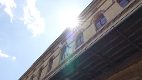 a-shot-of-an-old-building-with-windows-where-the-rays-of-the-sun-peek-out-on-the-roof