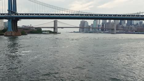 Drohne-Fliegt-Tief-über-Dem-East-River-Unter-Der-Manhattan-Bridge,-Um-Brooklyn-Bridge-Und-Waterfront-Park-Zu-Etablieren