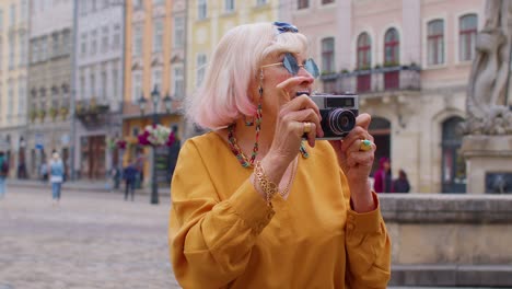 Turista-Anciana-Tomando-Fotografías-Con-Cámara-Fotográfica-En-El-Centro-De-La-Ciudad-De-Verano,-Vida-Después-De-La-Jubilación