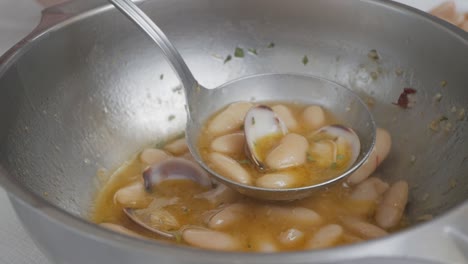 Someone-scoops-white-or-haricot-beans-stew-from-the-bottom-of-the-pot-at-one-of-the-finest-restaurant-in-Spain