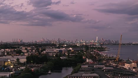 Panoramic-aerial-rise-establishing-shot-of-NYC-skyline-at-dusk-with-sparkling-lights-from-buildings