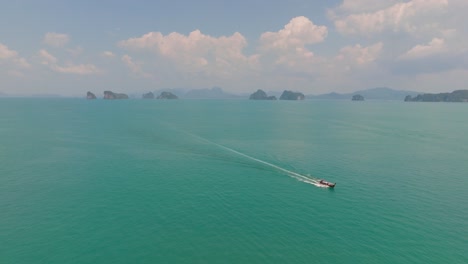 4K-aerial-drone-footage-of-long-tail-boat-exploring-Thai-islands,-Andaman-see,-Thailand,-Asia