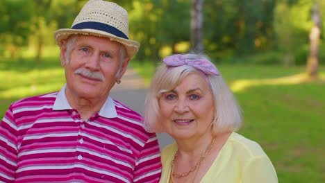 Senior-stylish-pensioners-couple-grandmother-grandfather-walking,-enjoying-time-together-in-park