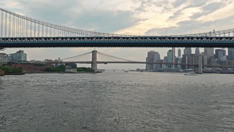 Niedrige-Lufttransportwagen-über-Dem-Wasser-Zur-Brooklyn-Bridge-Mit-Waterfront-Park-Und-Attraktionen