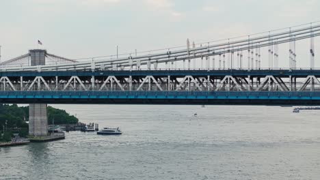 Aerial-trucking-pan-along-Manhattan-bridge-with-road-above-and-subway-tracks-in-lower-tier