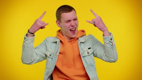 Overjoyed-teen-man-showing-rock-n-roll-gesture-by-hands,-cool-sign,-shouting-yeah-with-crazy-face