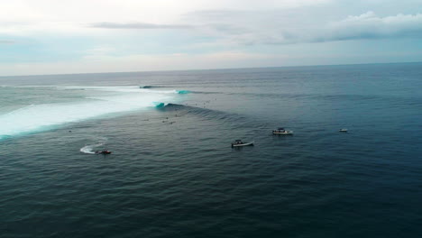 Drones-Orbitan-Sobre-Barcos-De-Apoyo-Y-Una-Multitud-De-Surfistas-En-Cloudbreak-Fiji