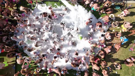 Slow-motion-aerial-footage-of-a-lively-foam-party-at-aqua-park