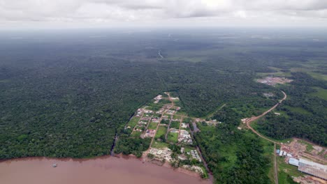 Aerial:-small-rural-village-in-the-amazon-jungle-by-the-river,-with-dirt-roads