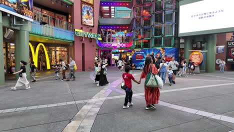 Menschen,-Die-Durch-Eine-Belebte-Einkaufsstraße-In-Japan-Mit-Geschäften-Und-Farbenfroher-Stadtlandschaft-Spazieren