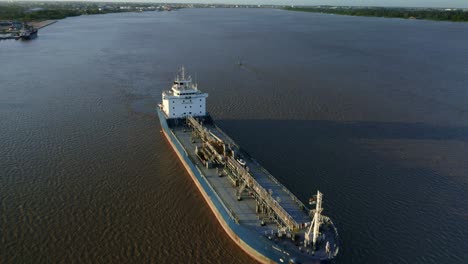 Aerial:-Oil-tanker-ship-sailing-in-Suriname-river,-drone-flyover