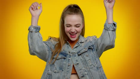 Teen-girl-in-denim-jacket-shouting,-raising-fists-in-gesture-I-did-it,-celebrating-success,-winning