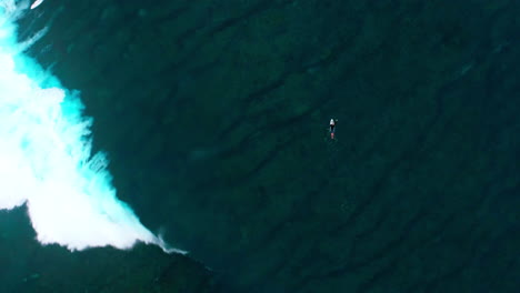 Eine-Drohne-Von-Oben-Umkreist-Einen-Surfer,-Der-Im-Ozean-Bei-Cloudbreak-(Fidschi)-Paddelt