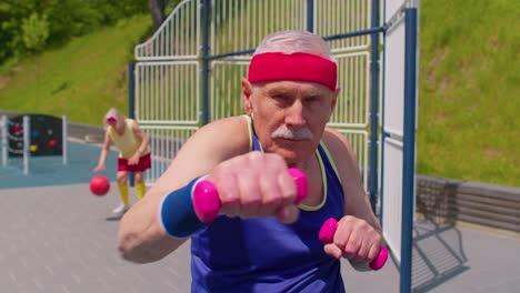 Senior-man-grandfather-doing-sport-training-boxing-fitness-aerobics-cardio-exercising-with-dumbbells