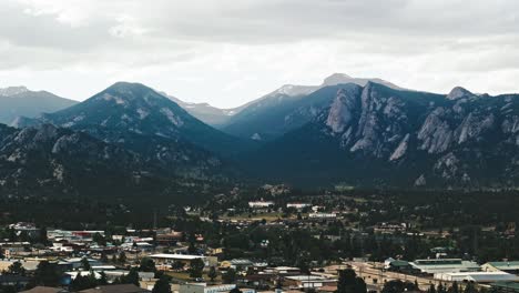 Light-cast-over-rocky-mountains-as-drone-descends-on-Estes-Park-on-cloudy-day