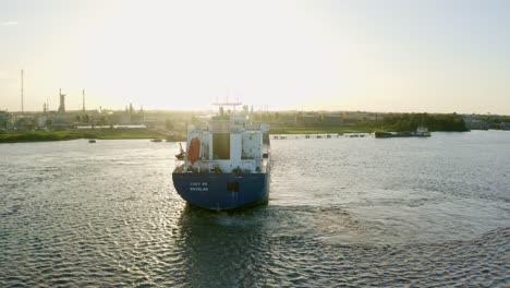 Aerial:-Oil-tanker-ship-getting-in-place-to-dock,-Staatsolie-refinery-in-background,-Suriname-river