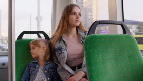 Tired-sleepy-woman-with-daughter-fall-asleep-in-public-tram-going-home-after-hard-working-day